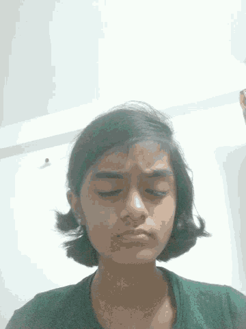 a girl with her eyes closed looks down at the camera