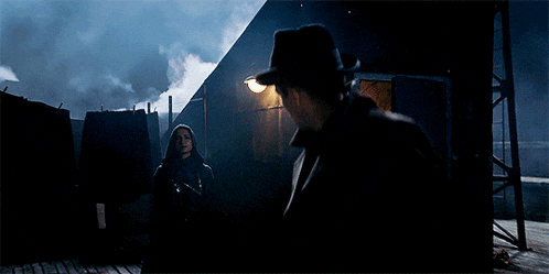 a man and a woman are standing in a dark room