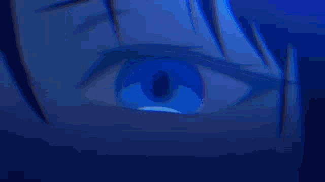 a close up of a person 's eye with a blue glowing circle in it .