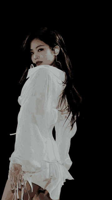 a woman with long black hair is wearing a white top