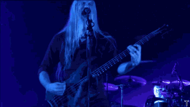 a man singing into a microphone while playing a bass