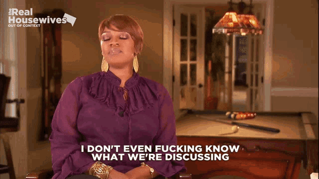 a woman is sitting in front of a pool table and says " i don t even fucking know what we 're discussing "