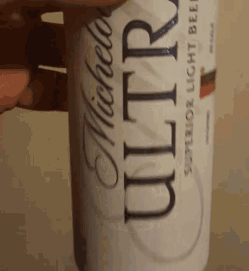 a person is holding a can of michelle ultra