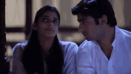 a man and a woman are looking into each other 's eyes .