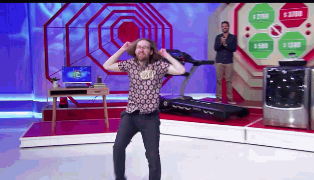 a man is dancing on a stage with a treadmill and a washer and dryer