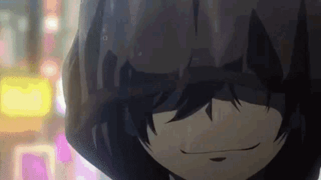 a close up of a person wearing a hooded jacket and smiling in the rain .