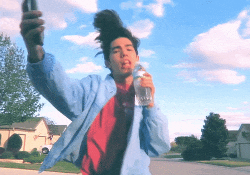 a man in a blue jacket is holding a bottle of water in his hand