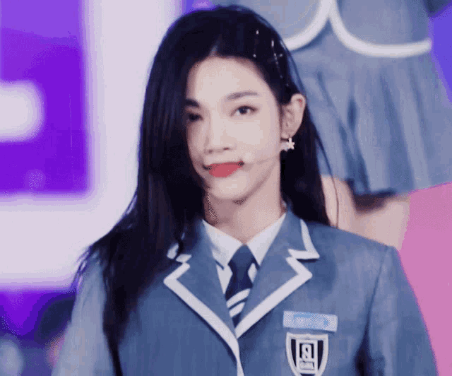 a girl in a school uniform has the letter r on her shoulder