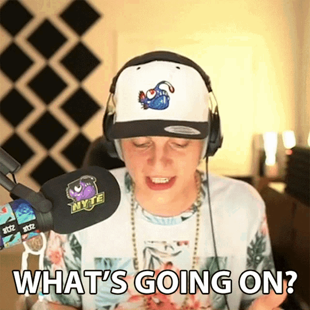 a man wearing headphones and a hat is asking what 's going on