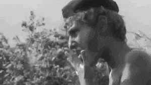 a man is smoking a cigarette in a black and white photo .