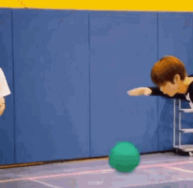 two boys are playing basketball on a court .