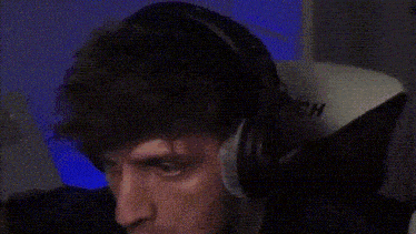a man is wearing headphones and sitting in a clutch chair .