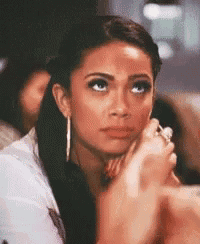 a woman with a ring on her finger is sitting in a chair with her hand on her face .