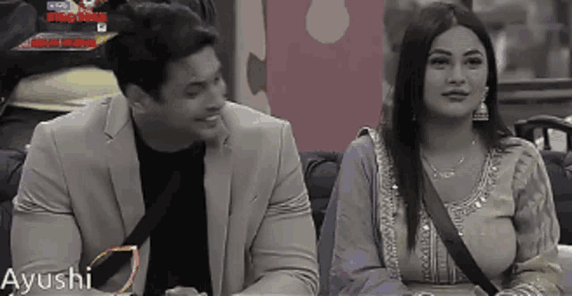 a man and a woman are sitting next to each other on a couch with ayushi written on the bottom
