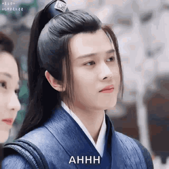 a man in a traditional costume is standing next to a woman and making a face .