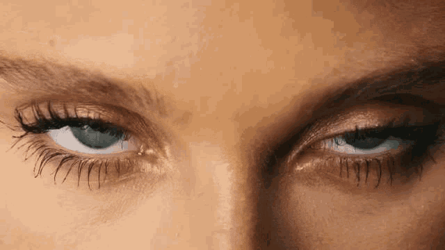 a close up of a woman 's blue eyes with mascara