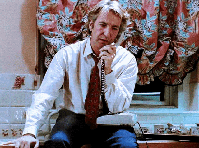a man in a tie is talking on a phone