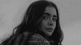 a black and white photo of a woman with long hair and a sweater .