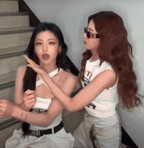 two women are standing next to each other and one of them is wearing a shirt that says ' t ' on it