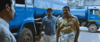 a group of men are standing next to a blue truck .