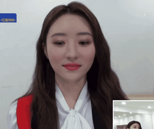 a woman with red lipstick and a white shirt with a bow tie is looking at the camera
