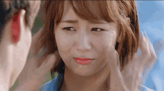 a man is touching a woman 's face while she is crying
