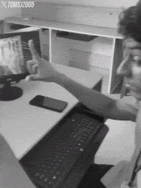 a black and white photo of a person giving a thumbs up with tomsj2005 written above them