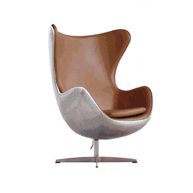 a chair with a blanket on it sits in a room with a lamp