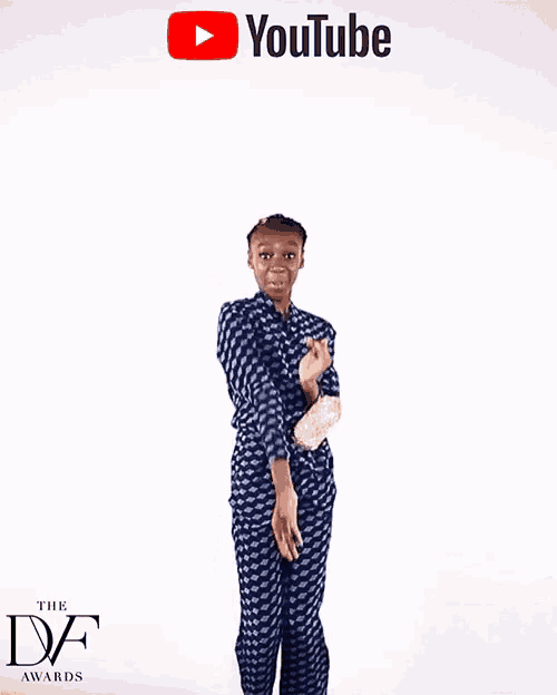 a woman in a blue jumpsuit is standing in front of a youtube logo