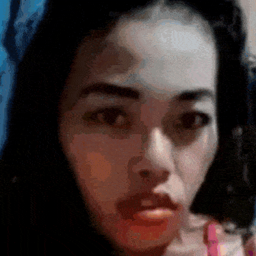 a close up of a woman 's face with a blurred background .