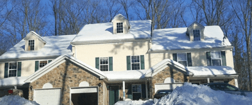a large house with snow on the roof and a car parked in front of it
