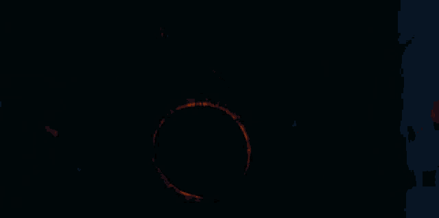 a woman with a ring on her back is standing in the dark