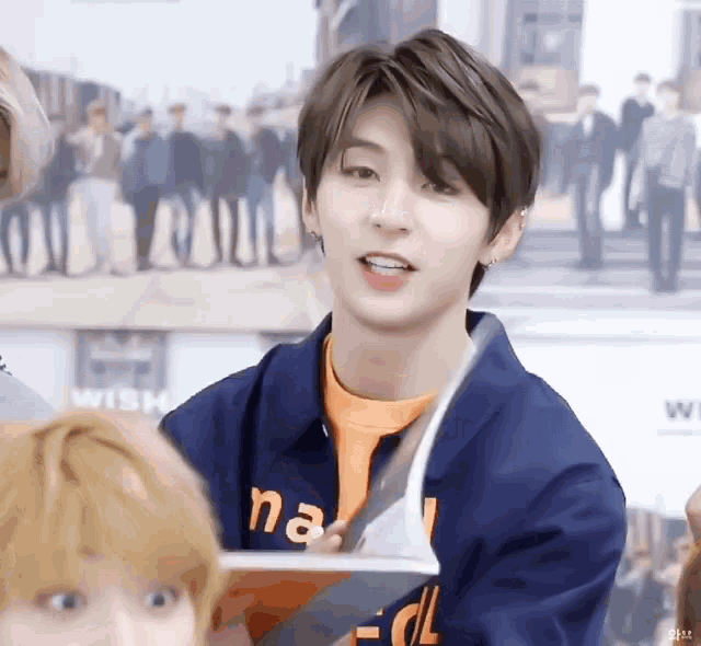 a young man wearing a blue jacket that says na on it