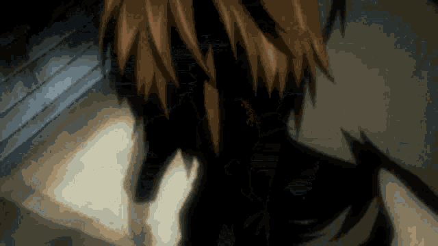 a close up of a person 's face in a dark room with a shadow on the wall .