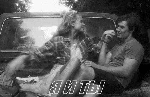 a man and a woman are sitting in the back of a truck holding hands .