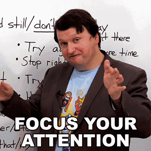 a man in front of a white board that says focus your attention on it