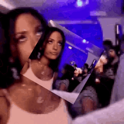 a woman is taking a selfie in front of a mirror with a purple background .