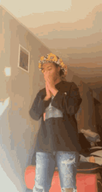 a person wearing a flower crown is covering their mouth
