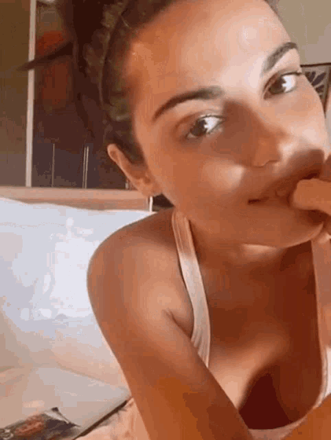 a woman is sitting on a bed with her mouth open .