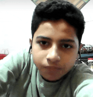 a young boy wearing ear buds looks at the camera