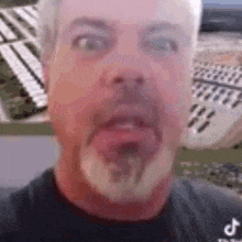 a man with a beard is making a funny face while standing in front of a keyboard .
