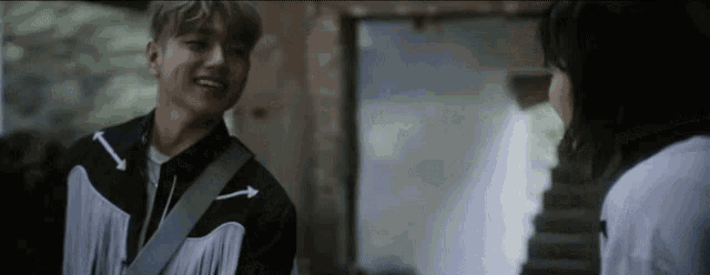 a man and a woman are talking to each other and the man is smiling .