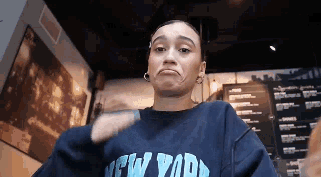 a woman wearing a blue sweatshirt that says new york
