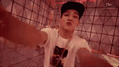 a young man wearing a white shirt and a black hat is taking a selfie .