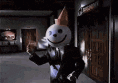 jack in the box is wearing a suit and tie and holding a burger .