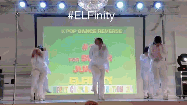 a group of people dancing in front of a screen that says #elfinity