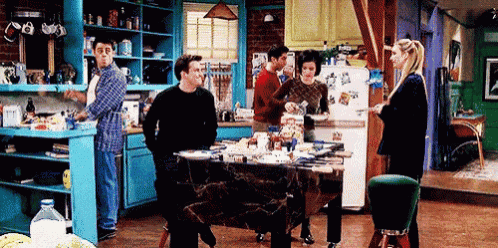a group of people standing around a table in a kitchen