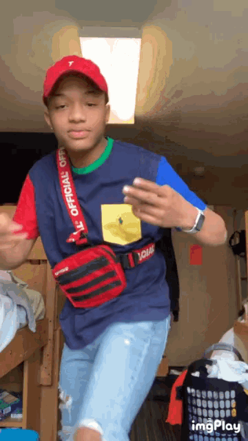 a young man wearing a red hat and a blue shirt with the word official on it