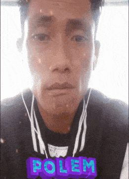 a man wearing ear buds and a polem sticker on his shirt