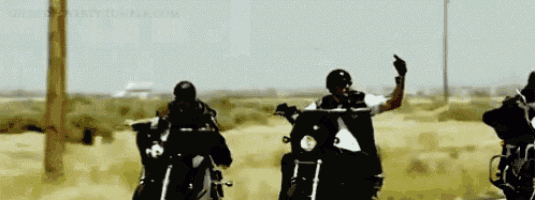a group of men are riding motorcycles on a dirt road